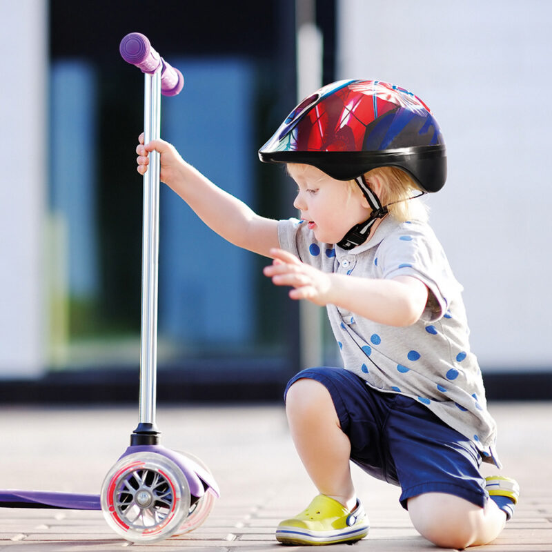 Toddler boy learning to ride scooter 3962308
